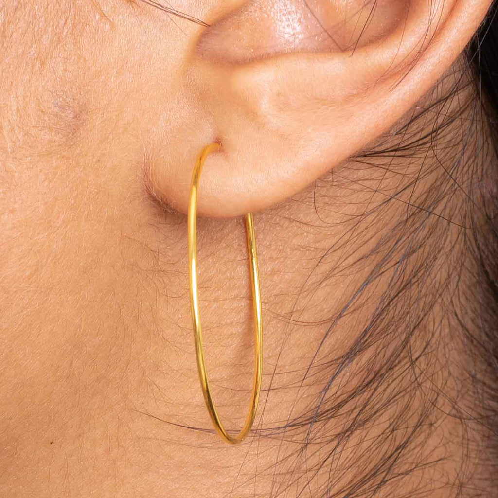 Close up of model styling the 14kt hoops